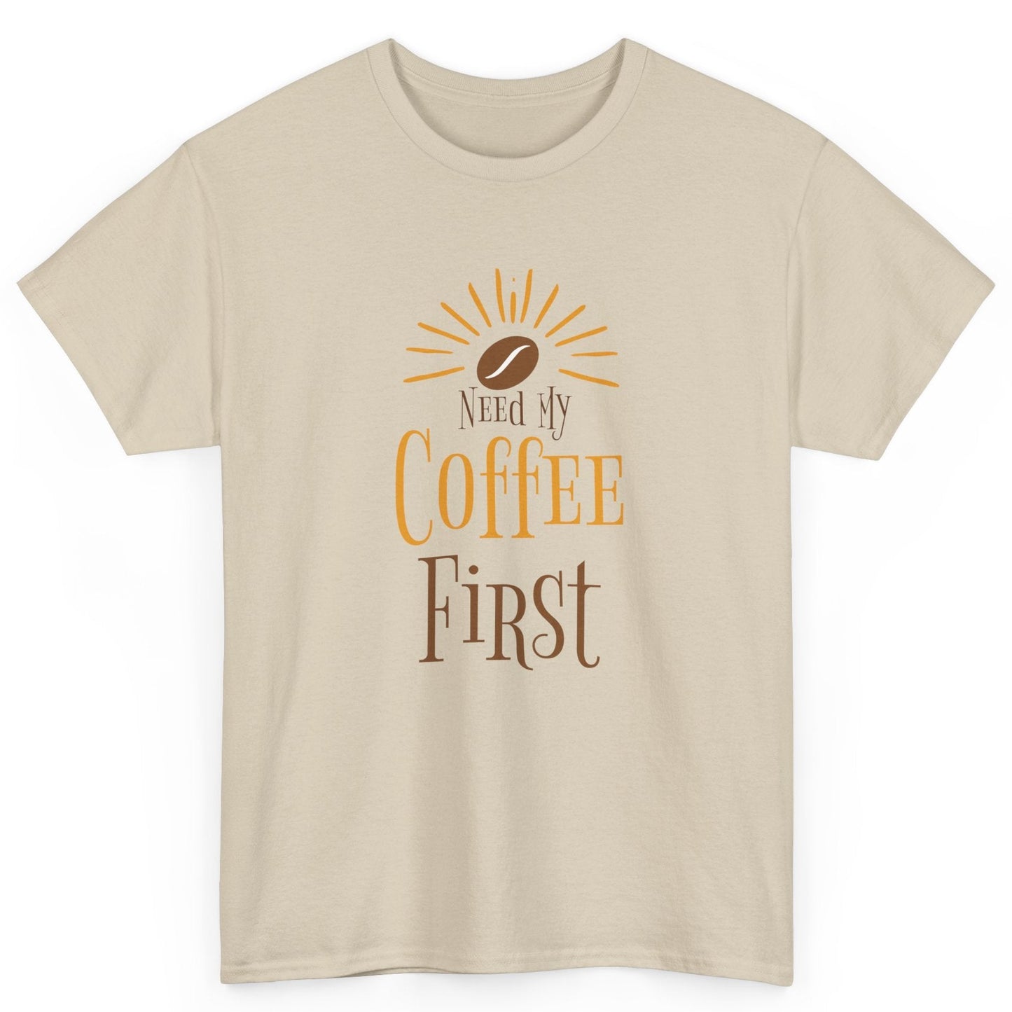 Beige t-shirt with 'Need My Coffee First' text and coffee bean graphic on a white background