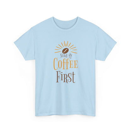 Light blue t-shirt with 'Need My Coffee First' text and coffee bean graphic on a white background