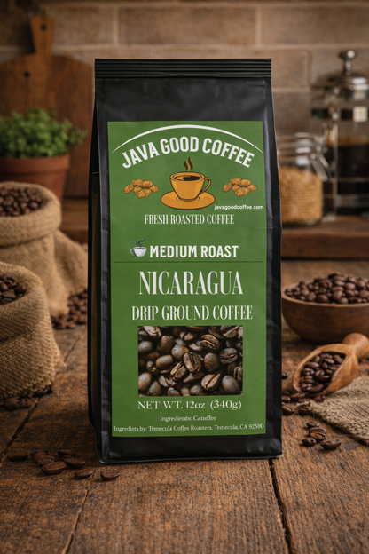 Java Good Coffee Nicaragua drip ground coffee package on a wooden surface with coffee beans and a coffee grinder in the background.
